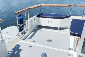Slide: The Image of 2022 Targa 32 boat deck with seating, wooden railings, and ocean view. - 5