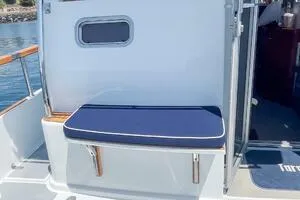 Slide: The Image of 2022 Targa 32 boat with blue cushioned seating and window, docked on a sunny day. - 6