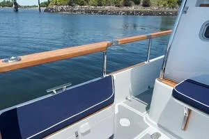 Slide: The Image of Targa 32 boat deck, 2022 model, featuring wooden railings and blue seating by the water. - 7