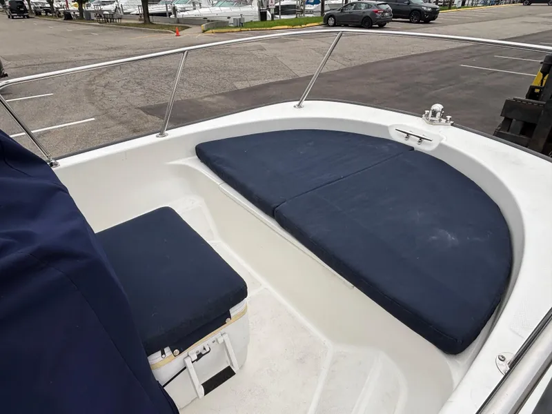 Slide: The Image of 2016 Boston Whaler 150 Montauk boat interior with blue cushions and railing. - 11