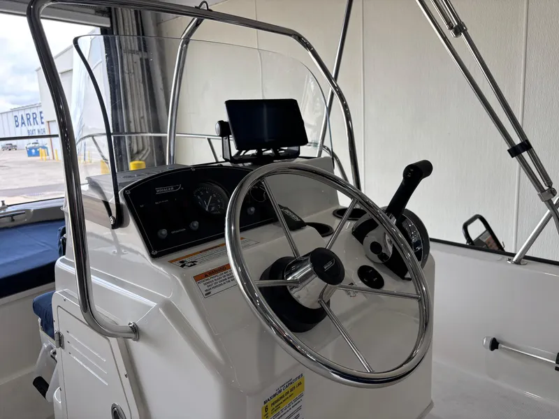 Slide: The Image of 2016 Boston Whaler 150 Montauk boat console with steering wheel and controls. - 14
