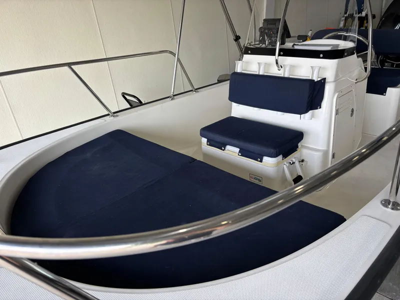 Slide: The Image of 2016 Boston Whaler 150 Montauk interior with blue seating and console. - 15