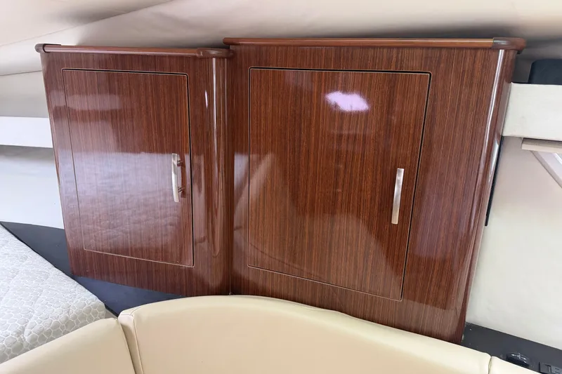 Slide: The Image of 2014 Regal 35 Sport Coupe boat kitchenette with sink, fridge, and storage cabinets. - 10