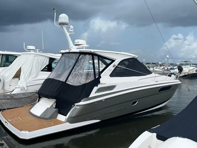The Image of 2014 Regal 35 Sport Coupe docked at marina under cloudy sky. - 11
