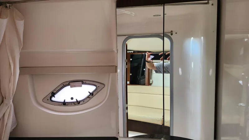 Slide: The Image of Bow of 2014 Regal 35 Sport Coupe with speakers and anchor, on calm water. - 2