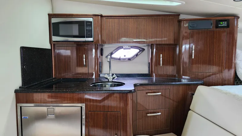 Slide: The Image of 2014 Regal 35 Sport Coupe interior kitchen with wood cabinetry and modern appliances. - 25