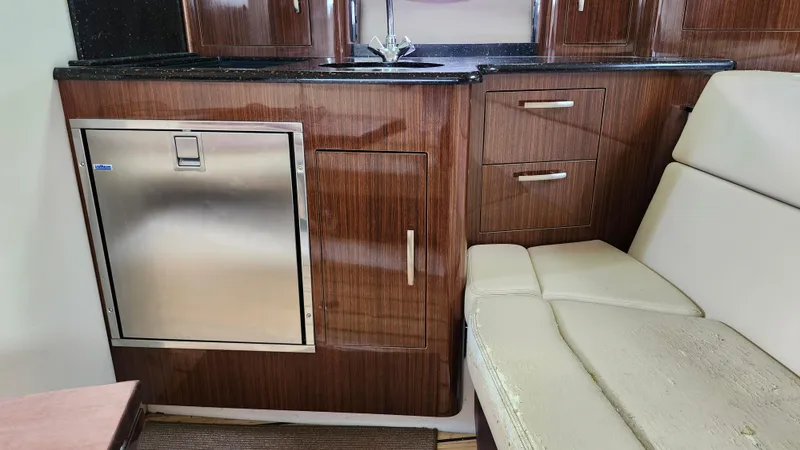 Slide: The Image of Interior of 2014 Regal 35 Sport Coupe with wood cabinetry and stainless steel fridge. - 26