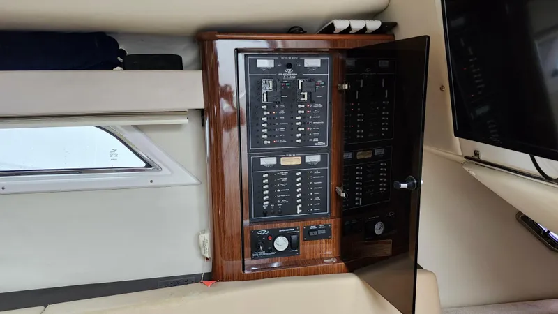 Slide: The Image of Electrical panel inside 2014 Regal 35 Sport Coupe boat cabin with wood finish. - 33