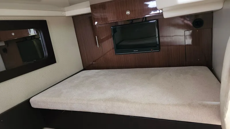 Slide: The Image of 2014 Regal 35 Sport Coupe interior cabin with bed and TV. - 35