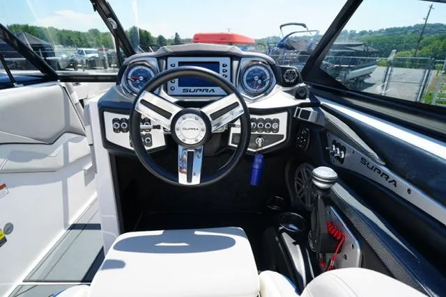 Slide: The Image of Interior of a 2016 Supra SA400-550 boat, featuring a sleek steering wheel and modern dashboard. - 11