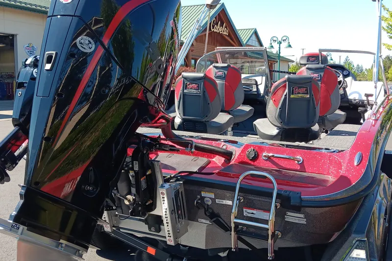 Slide: The Image of 2025 Ranger 620FS Cup Equipped boat with red and black design, parked near Cabela's store. - 5