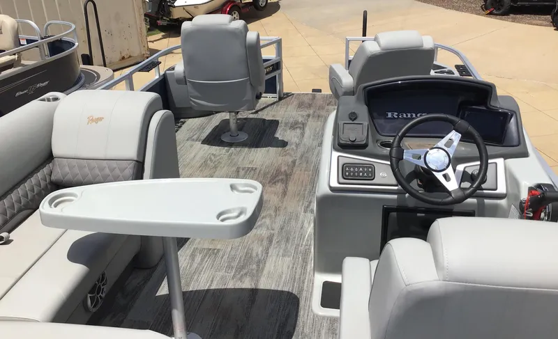 Slide: The Image of 2024 Ranger Reata 220F boat interior with steering wheel, seating, and table. - 2