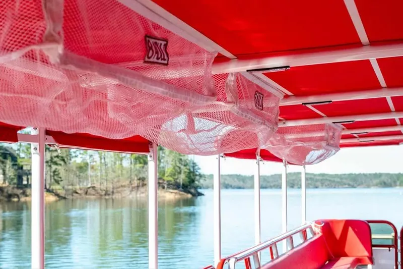 Slide: The Image of 2024 Aloha Pontoon 50' Water Taxi interior with red canopy and lake view. - 10