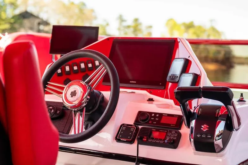 Slide: The Image of 2024 Aloha Pontoon 50' Water Taxi dashboard with steering wheel and control panel. - 7