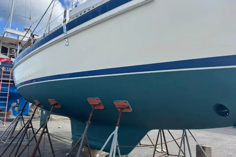 Slide: The Image of 2002 Pacific Seacraft 40 sailboat on stands, blue hull, white deck, marina setting. - 10