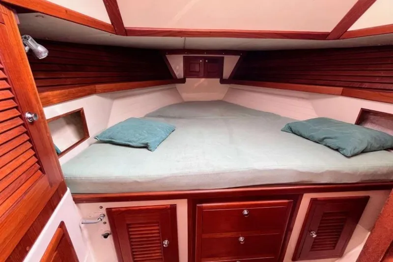 Slide: The Image of Cozy cabin interior of 2002 Pacific Seacraft 40 sailboat with wooden accents and bedding. - 24