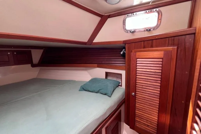 Slide: The Image of Cozy cabin interior of 2002 Pacific Seacraft 40 sailboat with wooden accents and bedding. - 25
