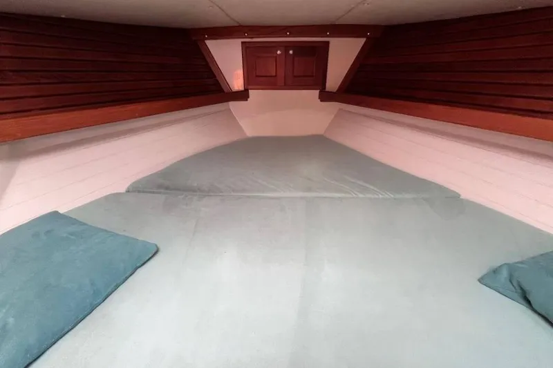 Slide: The Image of Cozy cabin interior of 2002 Pacific Seacraft 40 sailboat with wooden accents and blue bedding. - 27