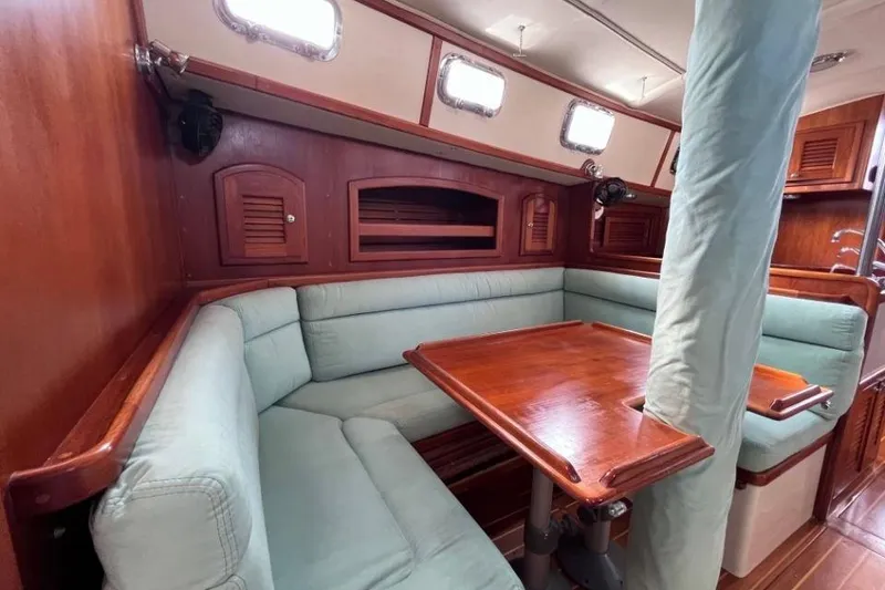 Slide: The Image of Interior of 2002 Pacific Seacraft 40 sailboat with wooden table and cushioned seating. - 30