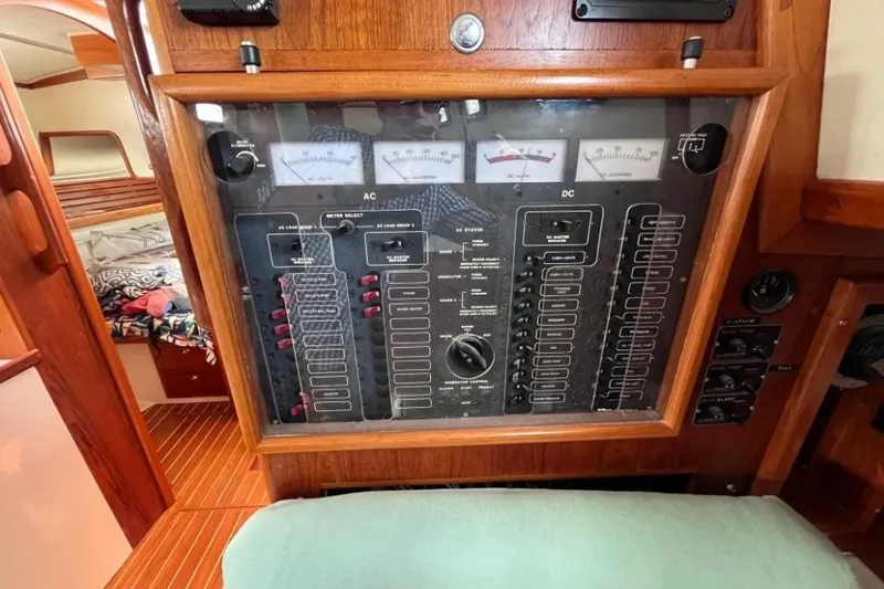 Slide: The Image of Electrical control panel on a 2002 Pacific Seacraft 40 sailboat, featuring AC and DC meters. - 36
