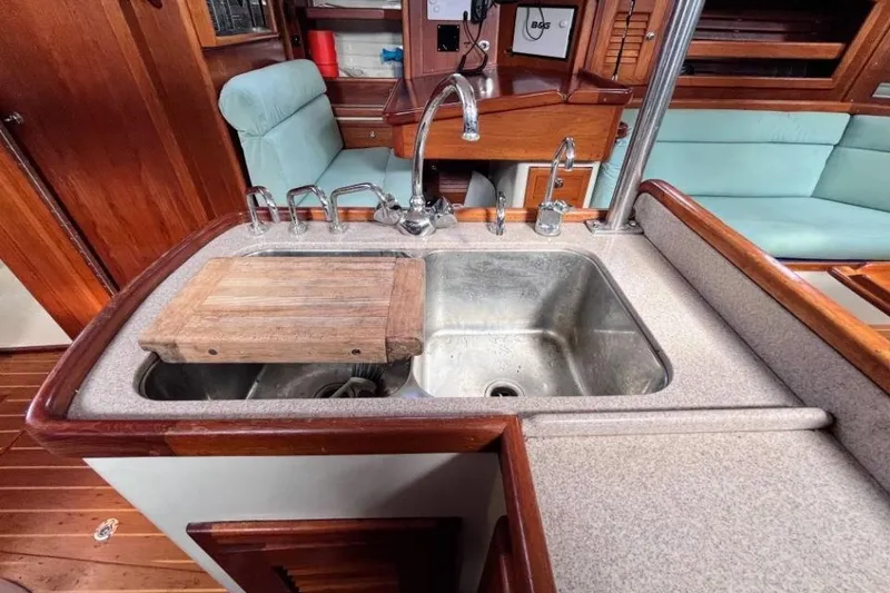 Slide: The Image of Galley sink area in 2002 Pacific Seacraft 40 yacht with wooden accents and seating. - 40