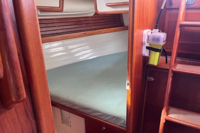 Slide: The Image of Cozy cabin interior of 2002 Pacific Seacraft 40 sailboat with wooden finish and comfortable bedding. - 44