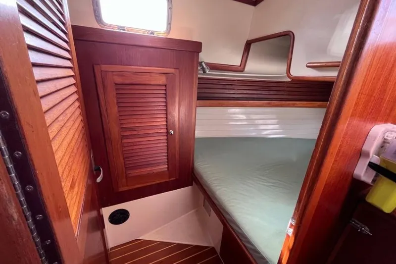 Slide: The Image of Cozy cabin interior of 2002 Pacific Seacraft 40 sailboat with wooden finishes and bed. - 45
