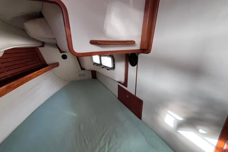 Slide: The Image of Interior cabin of 2002 Pacific Seacraft 40 sailboat, featuring wooden accents and a small window. - 46