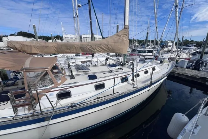 Slide: The Image of 2002 Pacific Seacraft 40 sailboat docked at marina, featuring beige sail cover. - 6