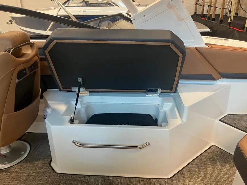 Slide: The Image of 2025 Cobalt R6 boat interior with open storage compartment and brown seating. - 12
