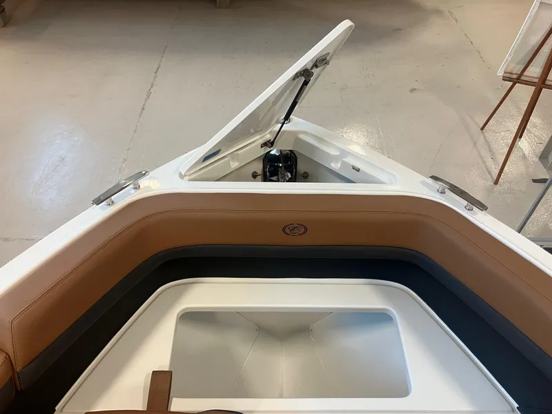 Slide: The Image of 2025 Cobalt R6 boat interior with open storage compartment and brown seating. - 25