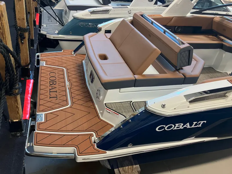 Slide: The Image of 2025 Cobalt R6 boat with tan seating and sleek design at a dock. - 3