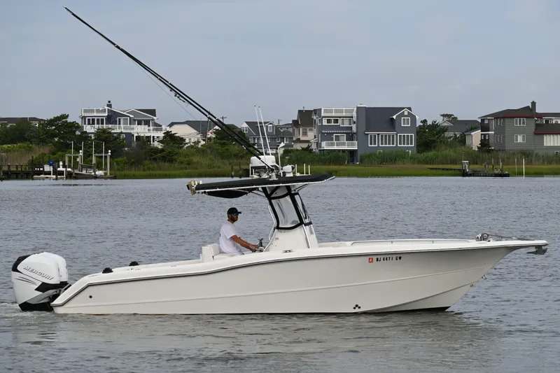 The Image of 2002 Triton 2895 CC boat on calm water near residential area. - 0