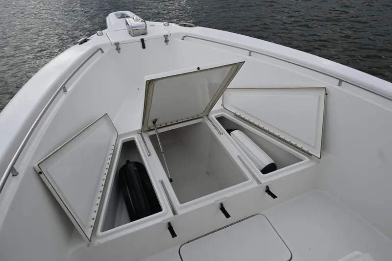 Slide: The Image of Open storage compartments on a 2002 Triton 2895 CC boat, docked on water. - 12