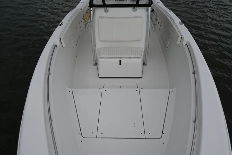 Slide: The Image of 2002 Triton 2895 CC boat interior with white seating and storage compartments. - 15