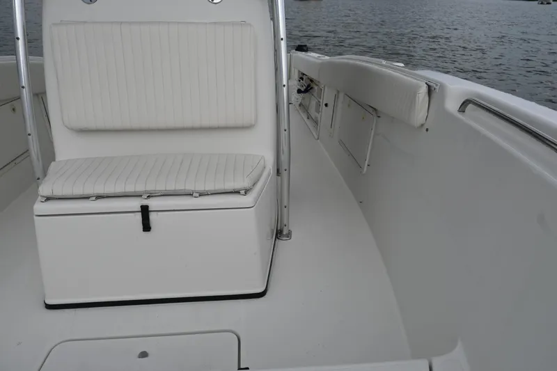 Slide: The Image of 2002 Triton 2895 CC boat interior with white seating and open deck on water. - 16