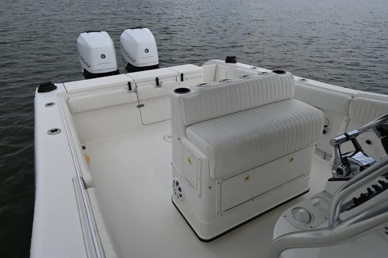 Slide: The Image of 2002 Triton 2895 CC boat with dual outboard engines on calm water. - 19