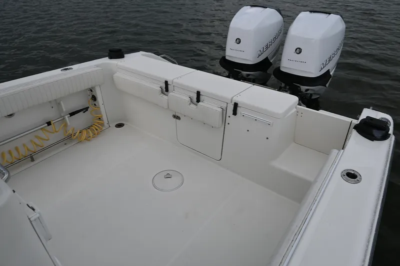 Slide: The Image of 2002 Triton 2895 CC boat with dual Mercury outboard engines on calm water. - 22