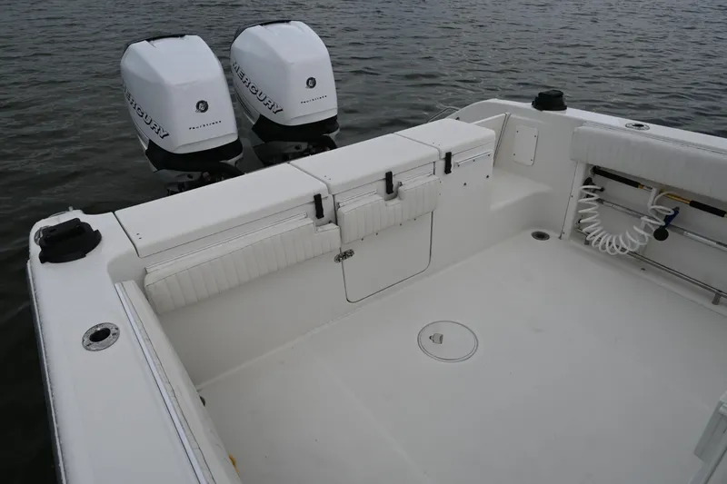 Slide: The Image of 2002 Triton 2895 CC boat with twin Mercury outboard engines on calm water. - 23
