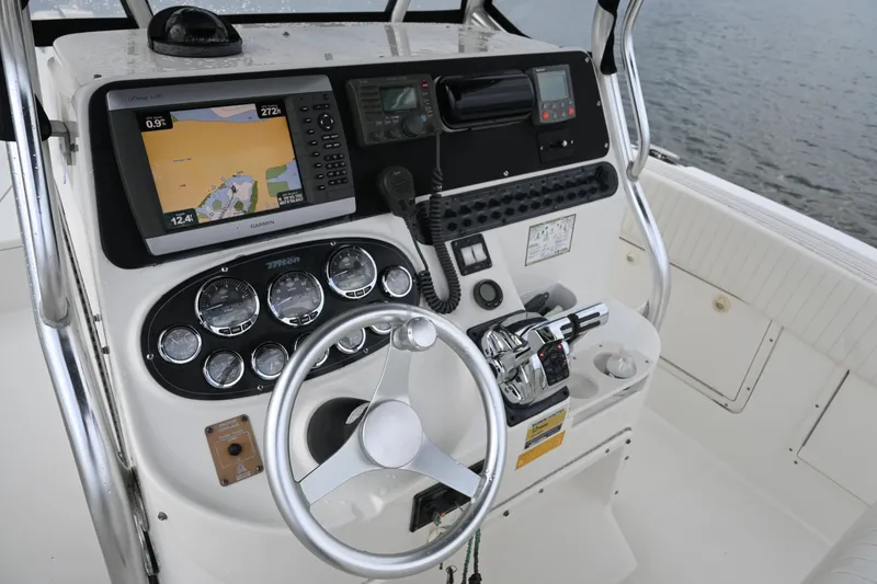 Slide: The Image of Triton 2895 CC 2002 boat dashboard with navigation equipment and steering wheel. - 27