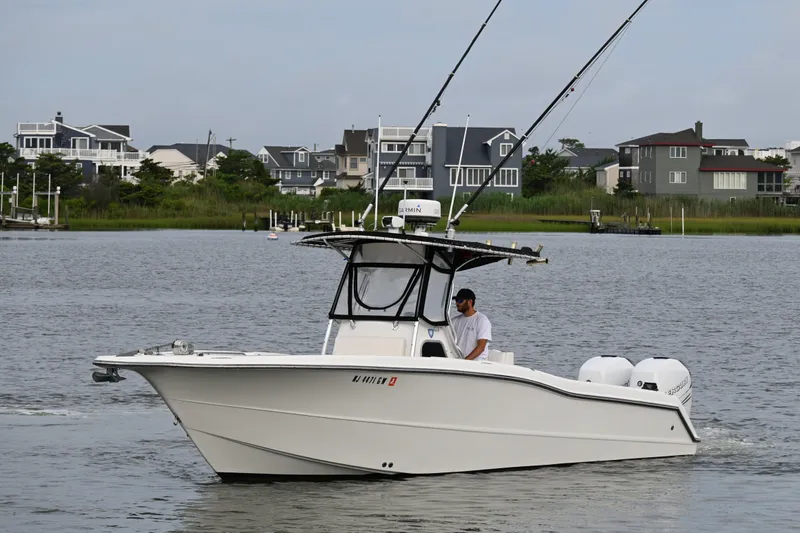 Slide: The Image of 2002 Triton 2895 CC boat cruising near waterfront homes. - 4