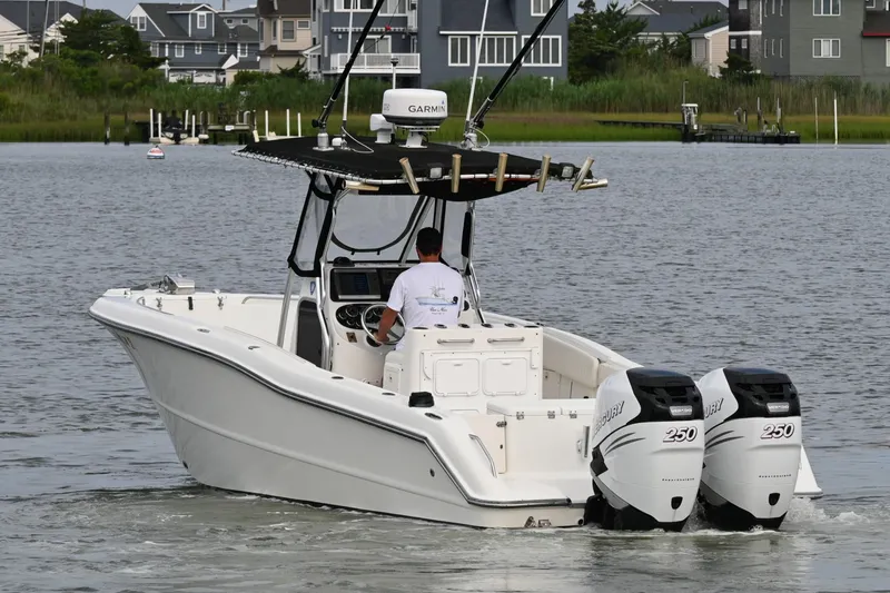 Slide: The Image of 2002 Triton 2895 CC boat with dual 250 horsepower engines on a calm waterway. - 6