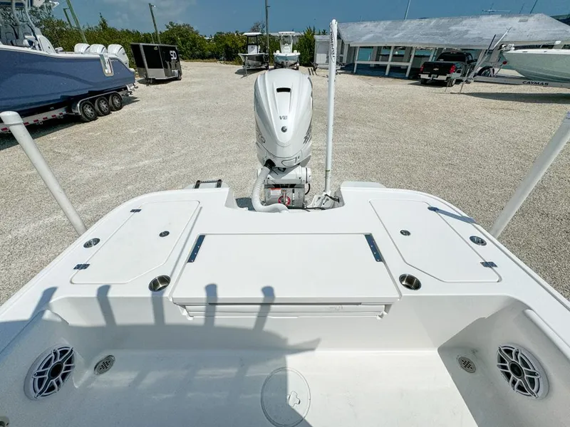 Slide: The Image of 2024 Caymas 28 HB boat deck with motor, spacious layout, and storage compartments. - 10