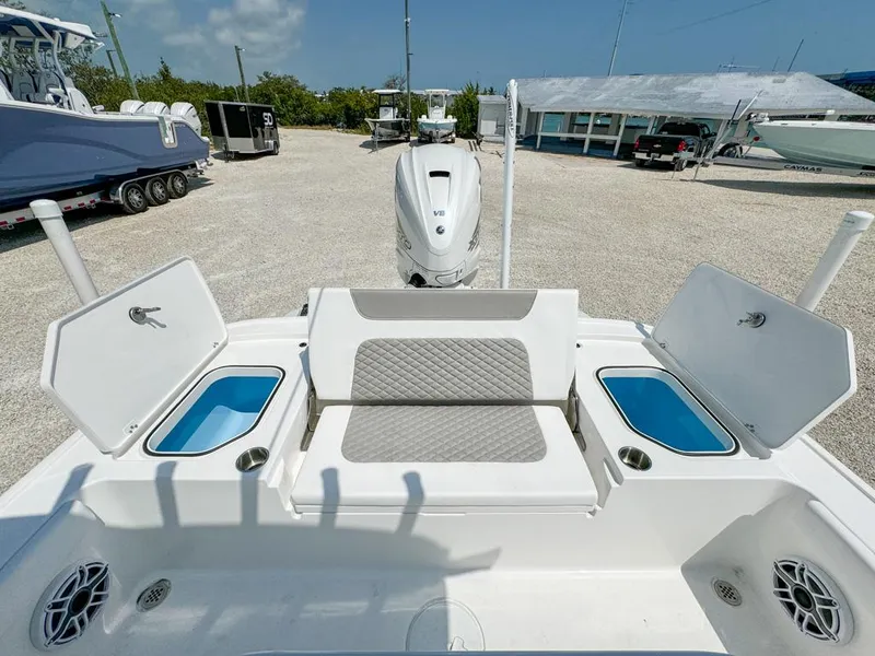 Slide: The Image of 2024 Caymas 28 HB boat with seating and storage compartments, parked outdoors. - 11