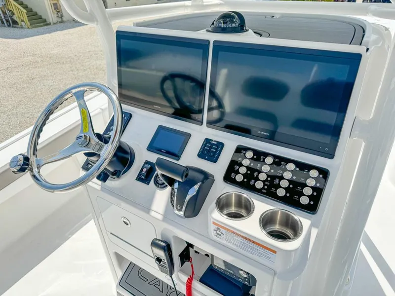 Slide: The Image of 2024 Caymas 28 HB boat dashboard with dual screens, steering wheel, and control panel. - 14