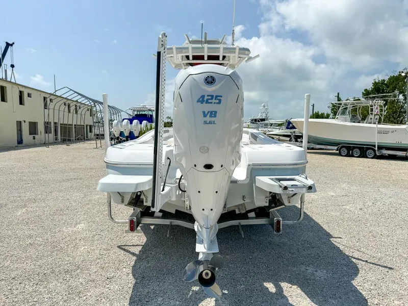 Slide: The Image of 2024 Caymas 28 HB boat with powerful 425 V8 engine, parked on gravel lot. - 6