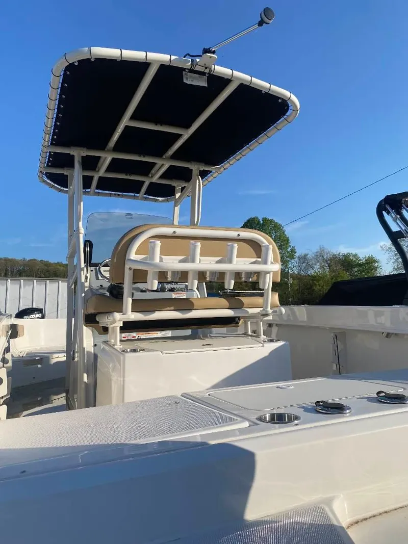 Slide: The Image of 2025 Bayliner Trophy T22CC boat with T-top and seating, under clear blue sky. - 5