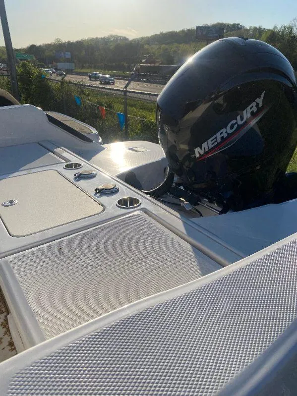 Slide: The Image of 2025 Bayliner Trophy T22CC boat with Mercury engine, parked near highway. - 7