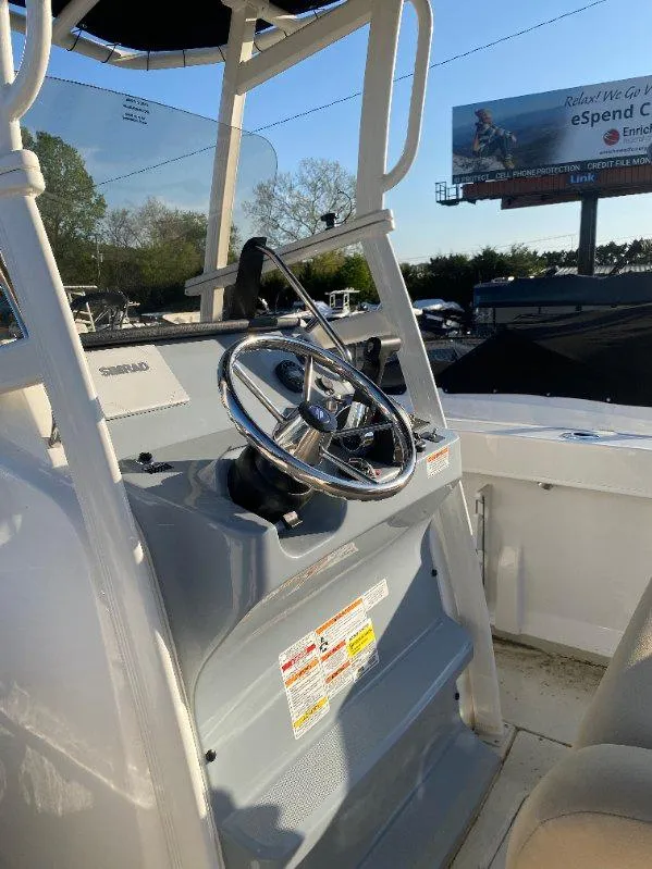 Slide: The Image of 2025 Bayliner Trophy T22CC boat console with steering wheel, outdoor setting. - 8