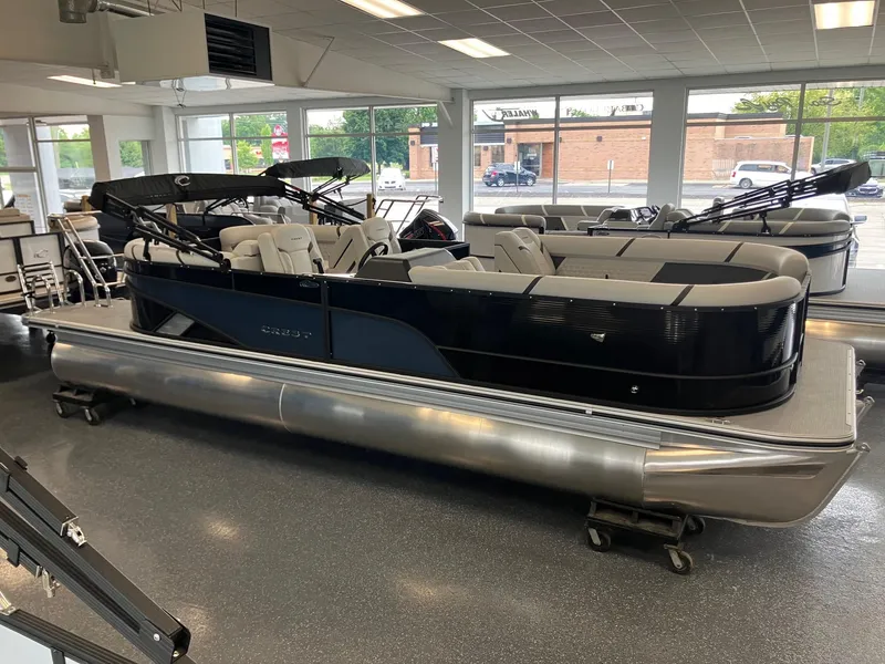 Slide: The Image of 2025 Crest 240 SLC Classic LX pontoon boat displayed in showroom, featuring sleek design and spacious seating. - 1